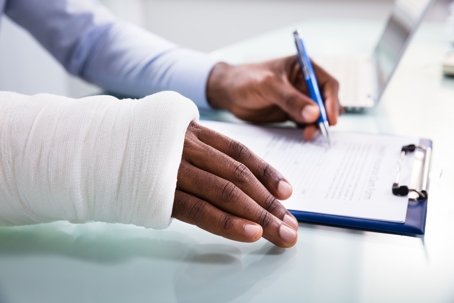 man with broken wrist and hand signing papers