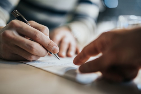Guy at table signing papers
