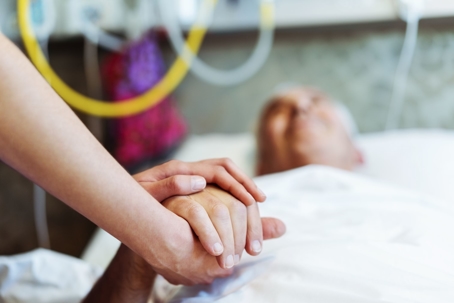 Patient in Hospital Bed Holding Hands