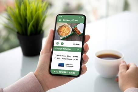 Person drinking coffee ordering food on phone