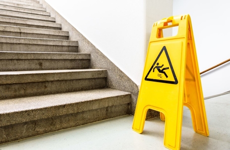Slippery floor sign at the bottom of stairs